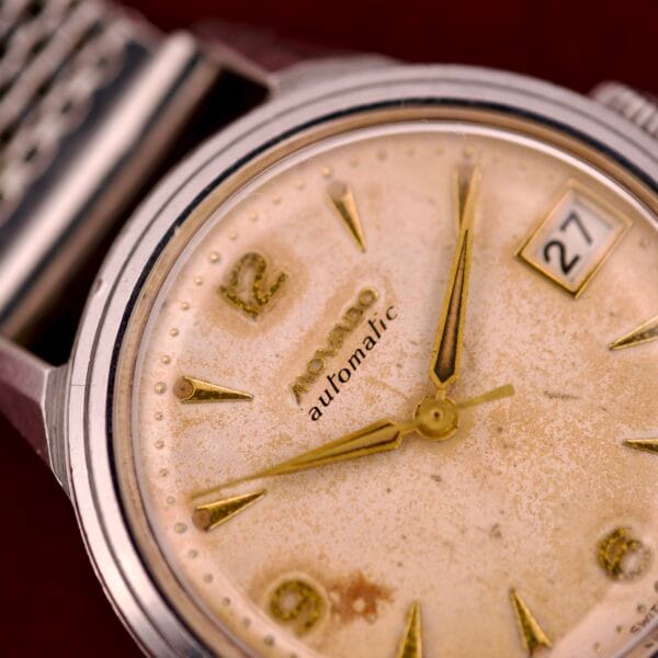 Close-up of a vintage Movado Automatic Date Ref. 16291 wristwatch, featuring a weathered dial, date display, and classic stainless steel case with Bumper Cal. 224A movement.