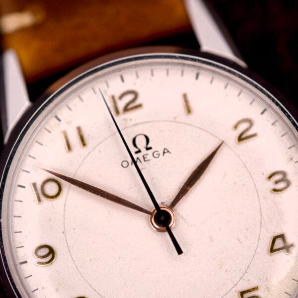Close-up of an Omega Ref. 2496 Arabic Numerals wristwatch with a stainless steel case, Cal. 30T2 SC movement, showing the time 10:08 and featuring a white dial with gold Arabic numerals.