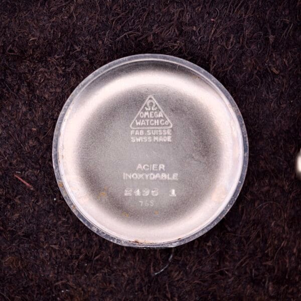 Omega Ref. 2496 Arabic Numerals Stainless Steel Case back with engraved text and logo, highlighting Cal. 30T2 SC, shown on a dark textured background.