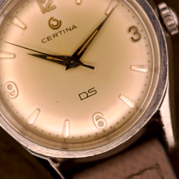 Close-up of a Certina DS Ref. 346.825 1st Gen Cal. 25-36 wristwatch featuring a beige face, brown leather strap, and stainless steel case, displaying the time at 9:19.