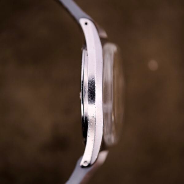 Side view of Certina DS Ref. 346.825 1st Gen with Cal. 25-36, shown in a stainless steel case against a blurred brown background.