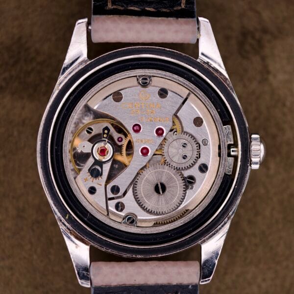 Close-up of a Certina DS Ref. 346.825 1st Gen in stainless steel, showcasing exposed mechanical gears and the Cal. 25-36 movement with the back cover removed.