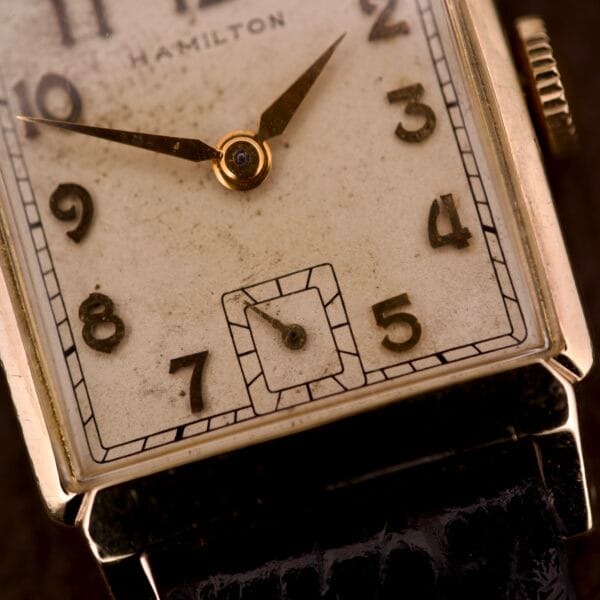 Close-up of a Hamilton Tank 14k Gold Filled Case Manual Wind Cal. 982 U.S.A. wristwatch featuring a rectangular face and refined gold detailing.