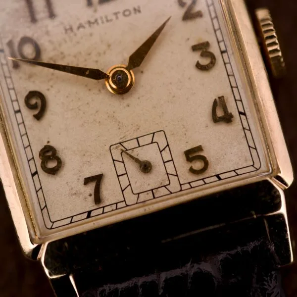Close-up of a Hamilton Tank 14k Gold Filled Case Manual Wind Cal. 982 U.S.A. wristwatch featuring a rectangular face and refined gold detailing.