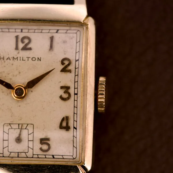 Close-up of a Hamilton Tank 14k Gold Filled Case Manual Wind Cal. 982 U.S.A. wristwatch with a square dial showing the numbers 12, 2, 3, and 4.