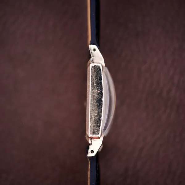 Close-up top view of a Hamilton Tank 14k Gold Filled Case Manual Wind Cal. 982 U.S.A. wristwatch with a leather strap on a brown surface.