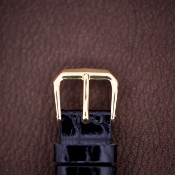 Hamilton Tank 14k Gold Filled Case Manual Wind Cal. 982 U.S.A. watch with a black leather strap, shown on a brown textured surface.