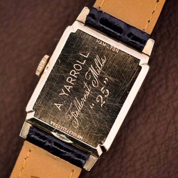 Hamilton Tank 14k Gold Filled Case Manual Wind Cal. 982 U.S.A. wristwatch engraved "A. YARROLL, Folckourt Mills, 25" on the back, with a tan and black leather strap and classic manual wind movement.
