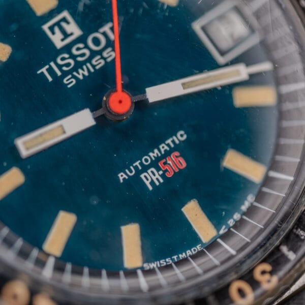 Close-up of a Tissot PR-516 "Roger Moore" Balkelite Bezel Ref. 44622, highlighting its dial, hands, markers, and Automatic text—a style famously worn by Roger Moore.