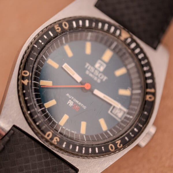 Close-up of the Tissot PR-516 "Roger Moore" Balkelite Bezel Ref. 44622, showcasing its vintage style with a classic Balkelite bezel and black textured strap.