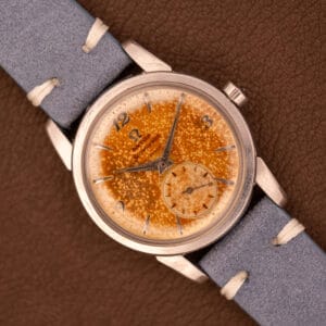 Omega Seamaster Automatic Tropic Dial Ref. 2848 Cal. 490 wristwatch with a speckled orange face and blue leather strap, displayed on a brown surface.