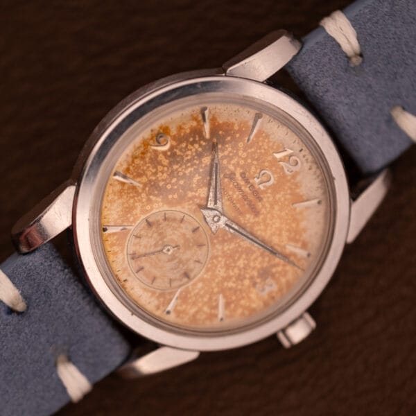 Omega Seamaster Automatic Tropic Dial Ref. 2848 Cal. 490 wristwatch with a speckled, patinated dial and blue suede strap, displayed on a brown background.