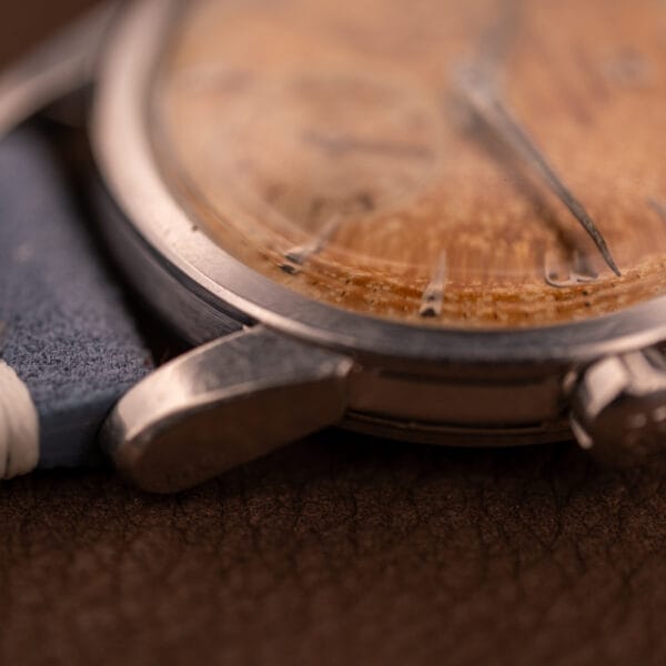 Close-up of an Omega Seamaster Automatic Tropic Dial Ref. 2848 Cal. 490 with a worn, foggy dial and blue strap, resting on brown leather.