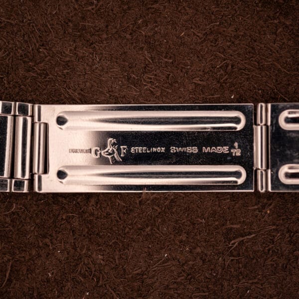 Close-up of a metal clasp engraved with STEELINOX SWISS MADE 1 72 and more, from a Movado HS 360 Kingmatic Video Blue Dial Ref. 409-705 Cal. 408.