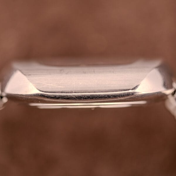 Close-up side view of a Movado HS 360 Kingmatic Video Blue Dial Ref. 409-705 Cal. 408 silver case against a soft brown background.