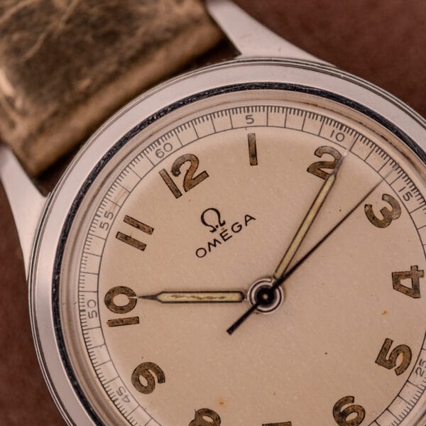 Close-up of an Omega WWII Era Military "US ARMY" Ref. 2179 Stainless Steel Cal. 30T2 SC watch with a tan leather strap, displaying the time as 10:10.