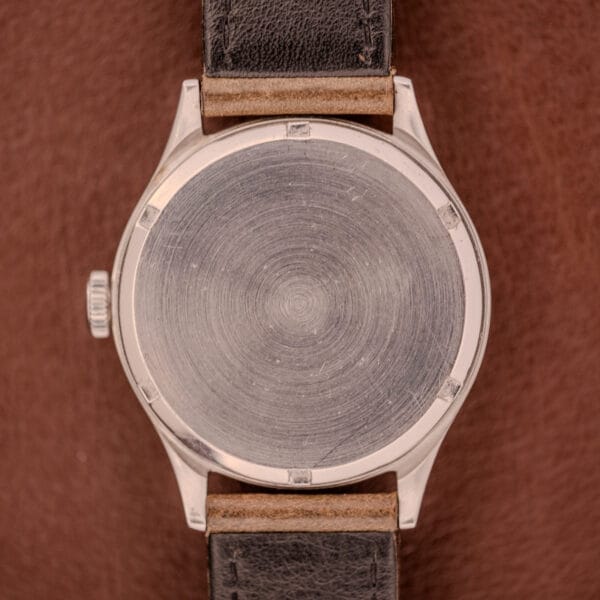 The back of an Omega WWII Era Military "US ARMY" Ref. 2179 Stainless Steel Cal. 30T2 SC, featuring a plain brushed case and dark leather strap reminiscent of US Army–issued watches.