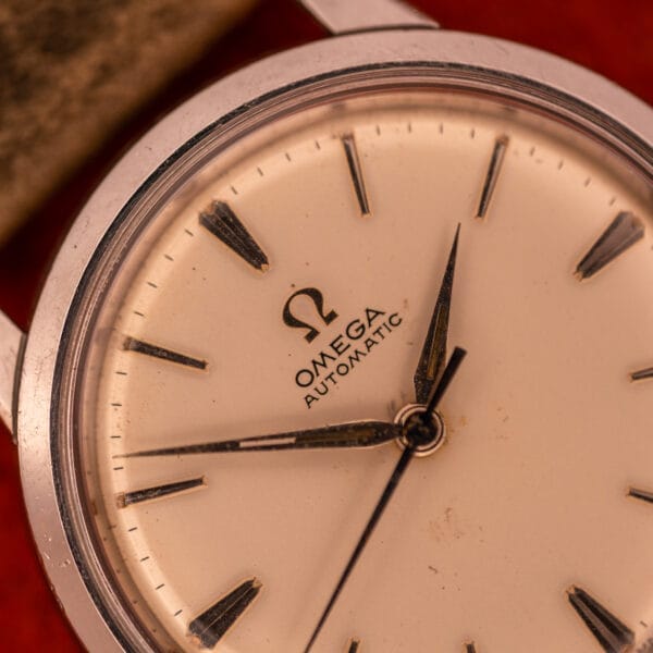 Close-up of the Omega Automatic Stainless Steel Ref. 14773, featuring black hands and hour markers on a cream dial with Cal. 470 movement, set in a sleek stainless steel case.