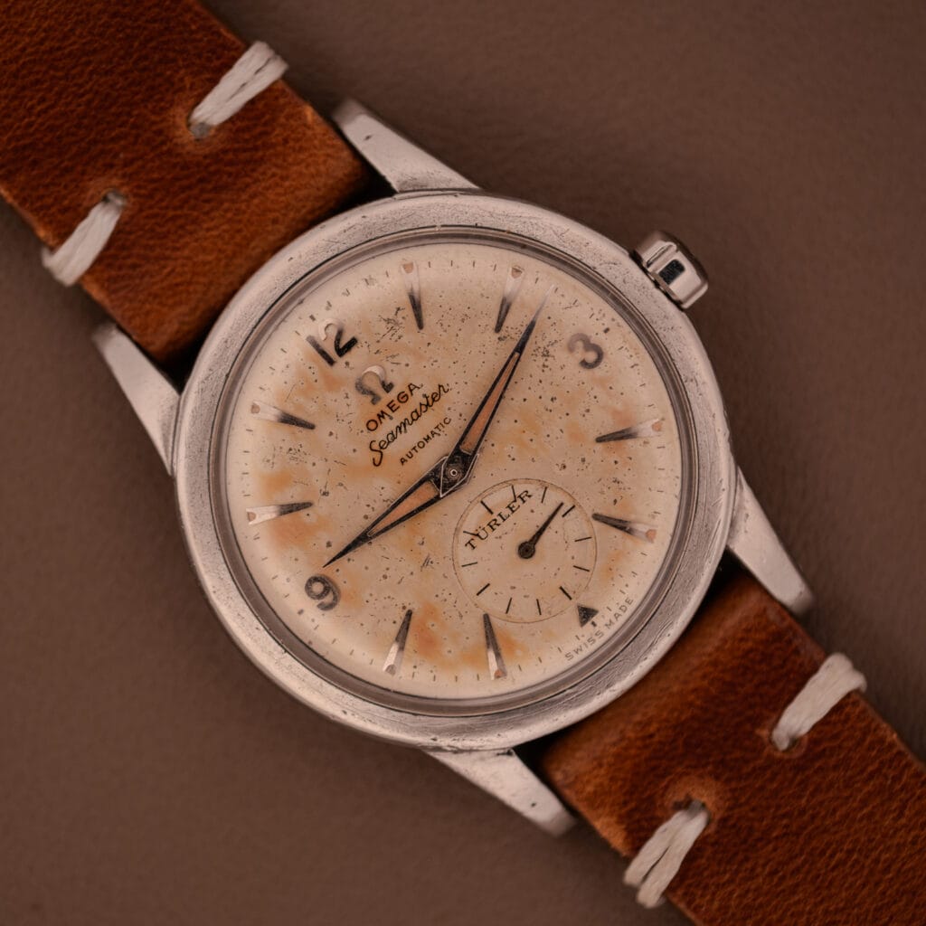 An Omega Automatic Seamaster Bumper "Türler Dial" Ref. 2576 wristwatch with a speckled cream dial and classic brown leather strap.
