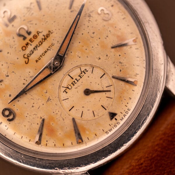 Close-up of an Omega Automatic Seamaster Bumper "Türler Dial" Ref. 2576 watch face, showing aged patina and a leather strap.