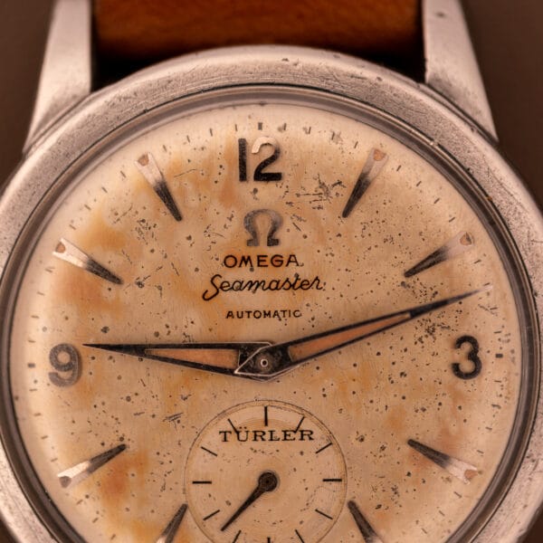 Close-up of an Omega Automatic Seamaster Bumper "Türler Dial" Ref. 2576 featuring a vintage, worn speckled dial and brown leather strap.