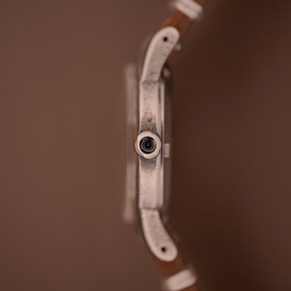 Side profile of the Omega Automatic Seamaster Bumper "Türler Dial" Ref. 2576 with a brown strap, highlighting the crown and distinctive dial, set against a brown background.