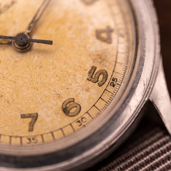 Close-up of an Omega Patina Dial Military "US ARMY" Ref. 2179 in stainless steel, featuring a worn dial showing numbers 3 to 7 and powered by the iconic Cal. 30T2 SC movement.