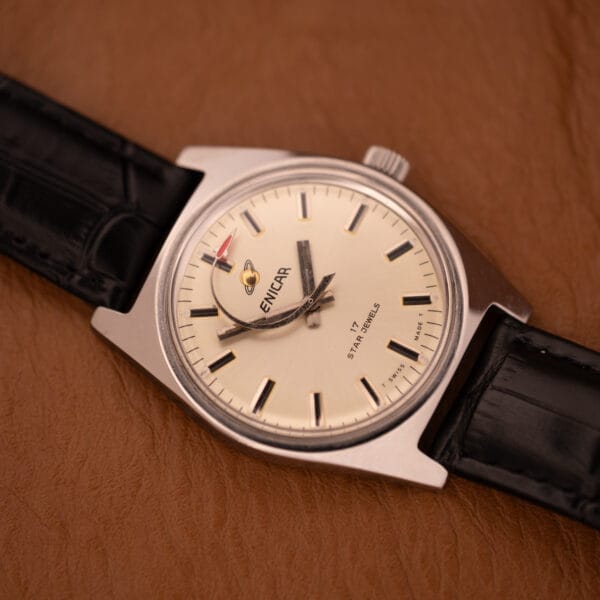 Enciar Ocean Peal 17 Star Jewels "Space Ship Seconds" Ref. 2334 wristwatch with a black leather strap, shown on a brown textured surface.