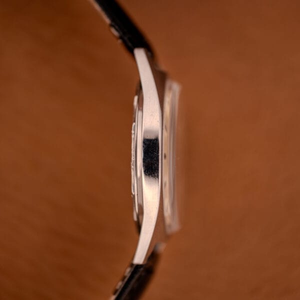 Side view of the Enciar Ocean Peal 17 Star Jewels "Space Ship Seconds" Ref. 2334 silver watch with a black strap, set against a soft brown background.