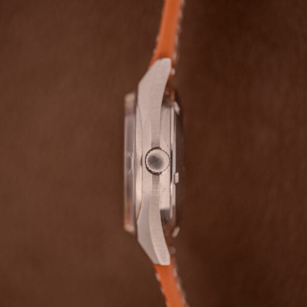 Side view of the Bulova Oceanographer Automatic 333 Feet with a blue/purple dial and orange strap, model Cal. 1132.10, set against a brown background.