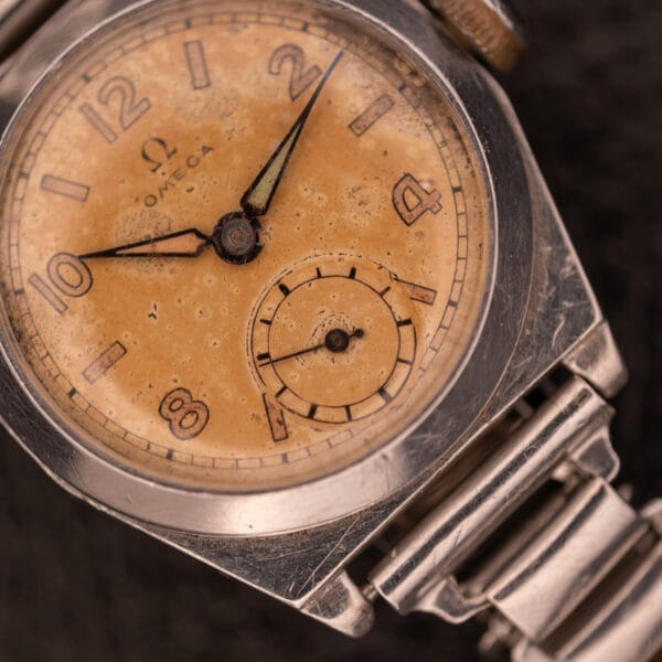 Close-up of a 1936 Omega Trench Watch with a tan dial and Hadley Staybrite Steel case, Cal. 23.4.