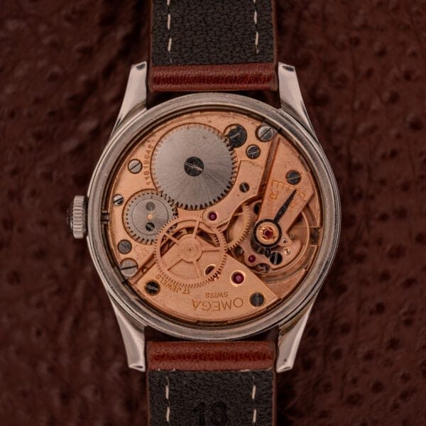 Close-up of the Omega Jumbo Stainless Steel Ref. 2640, featuring its exposed manual wind 283 caliber movement with intricate gears, cogs, and engraved details.