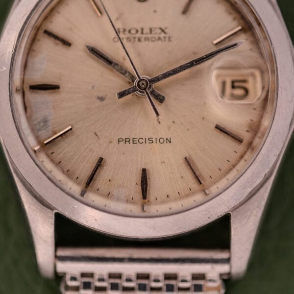Close-up of a Rolex Oysterdate Precision Ref. 6466 in stainless steel, featuring a beige dial, the date set to 15, and "PRECISION" text on the face.