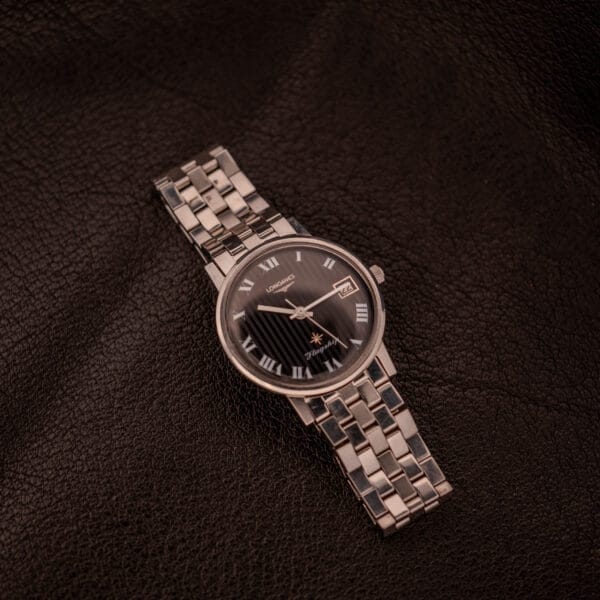 A Longines Flagship Ref. 2821 wristwatch with a black pinstripe dial and diamond Cal. 285 rests on dark brown textured leather.