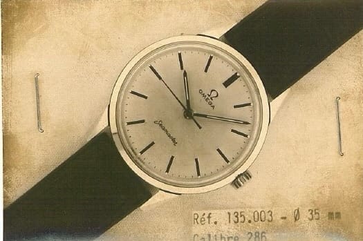 A vintage Omega Seamaster 30 wristwatch, reference 135.003, with a black strap, shown on a sepia-toned background.