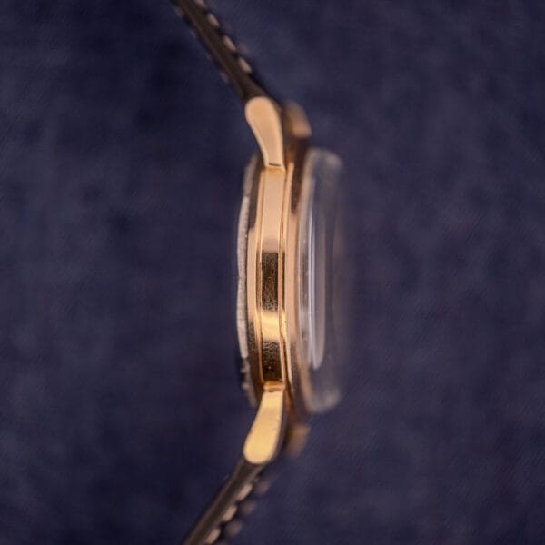 Side view of the Zodiac Glorious Automatic Tuxedo Dial Ref. 688 Cal. 1361 with a leather strap on a blue textured background.