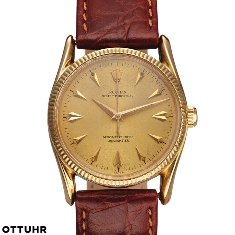 A vintage Rolex Oyster Perpetual 6593 in gold, featuring a worn dial and brown leather strap, exudes timeless elegance.
