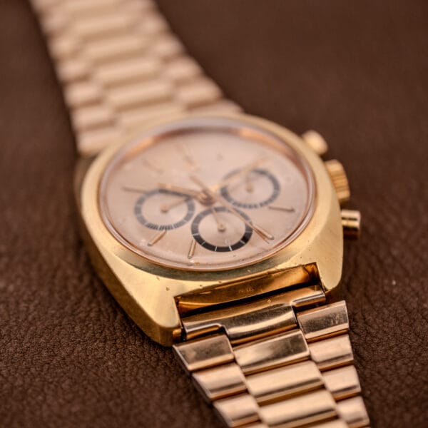 Omega Seamaster Chronograph Ref 145.029 Cal. 861 with three subdials, a round face, and metal link band displayed on a brown surface.