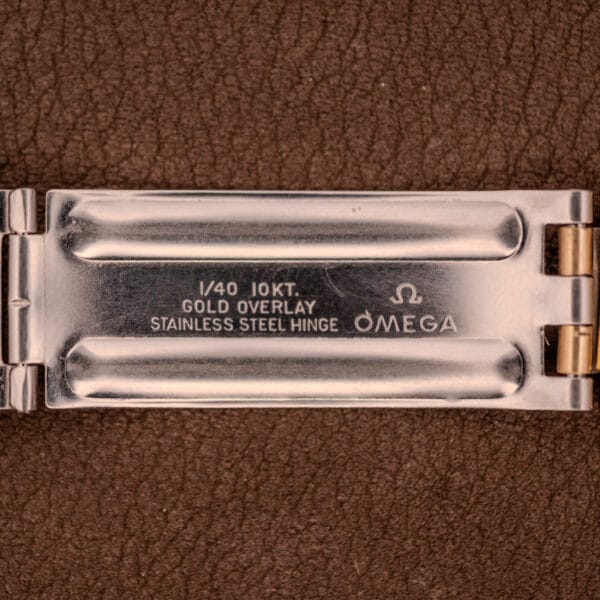 Close-up of an Omega Seamaster Chronograph Ref 145.029 Cal. 861 clasp, featuring "1/40 10KT Gold Overlay Stainless Steel Hinge" and "Cal. 861" engraved text.