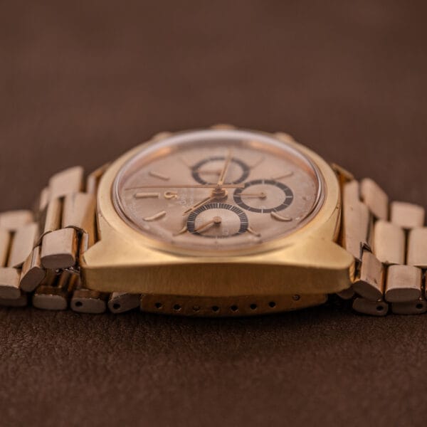 Omega Seamaster Chronograph Ref 145.029 with Cal. 861 movement and metal band, shown in a close-up photo on a brown textured surface.