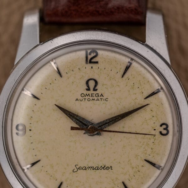 Close-up of an Omega Automatic Seamaster Ref. 2846-2848 in stainless steel, featuring a cream dial, brown leather strap, and the iconic Cal. 500 movement.