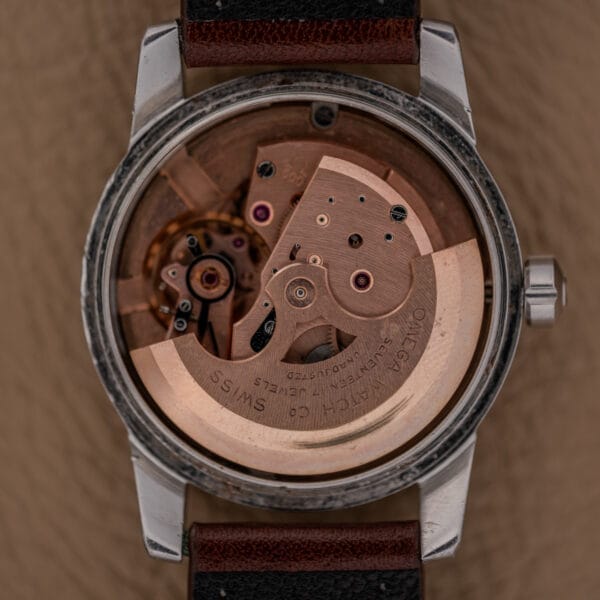 Close-up of an Omega Automatic Seamaster Ref. 2846-2848 in stainless steel, highlighting the exposed Cal. 500 automatic movement and its intricate gears and detailed engravings.