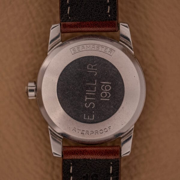 Back of an Omega Automatic Seamaster Ref. 2846-2848 stainless steel watch with Cal. 500, engraved with “E. STILL JR 1961,” “SEAMASTER,” and “WATERPROOF.”.
