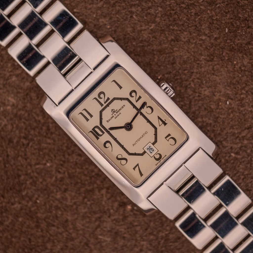Baume Mercier Hampton Automatic Large MV045120 stainless steel on three-row polished bracelet, champagne Art Deco dial, top-down on suede.