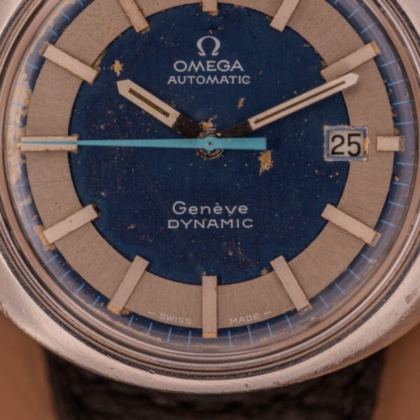Close-up of an Omega Automatic Geneve Dynamic Ref. 166.107 Cal. 1421 watch with a blue dial, highlighting its vintage charm and distinct signs of aging.