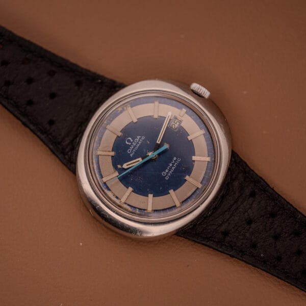 Omega Automatic Geneve Dynamic Ref. 166.107 Cal. 1421 wristwatch with blue and silver dial, black perforated leather strap, and automatic movement.