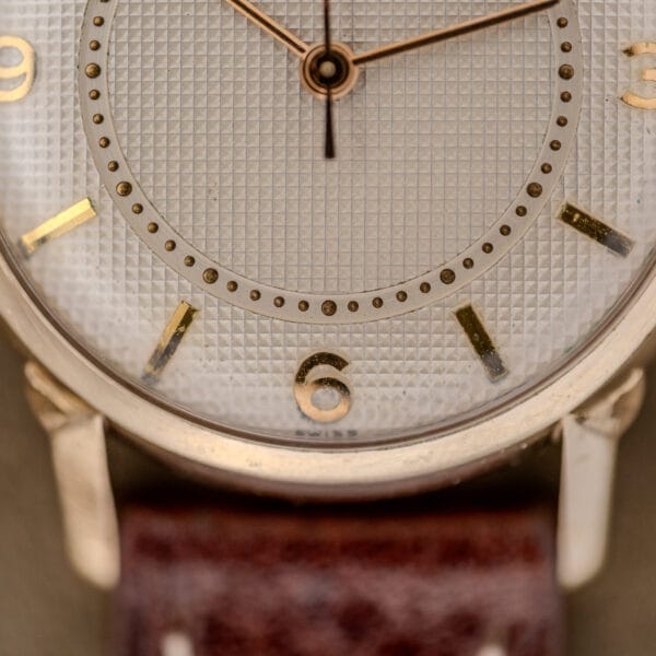 Close-up of a Wittnauer Automatic Waffle Dial Ref. 2023 watch featuring gold numbers, brown leather strap, 10k GF case, and Cal. 11ARB movement.