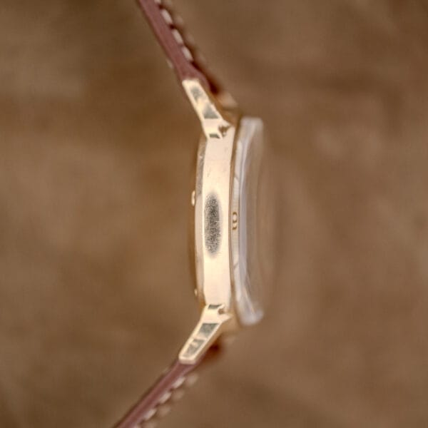 Side view of a Wittnauer Automatic Waffle Dial Ref. 2023 gold wristwatch with brown leather strap, 10k GF case (Cal. 11ARB), showing a worn area on the casing.