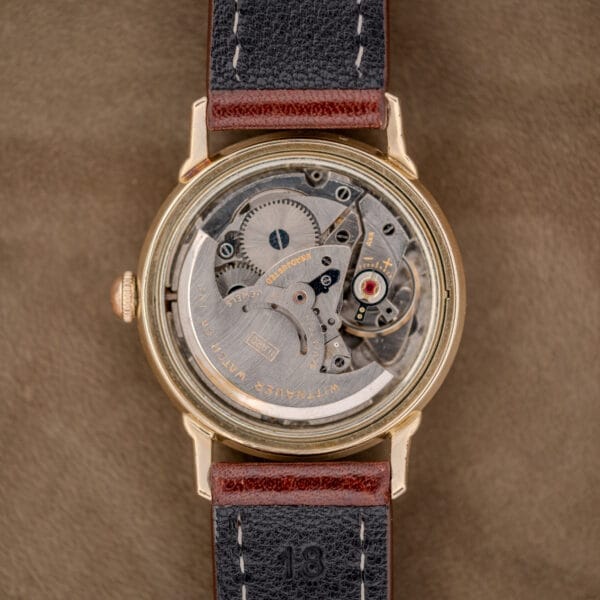 Close-up of a Wittnauer Automatic Waffle Dial Ref. 2023 watch with visible mechanical movement, brown leather strap, and classic 10k GF case, powered by Cal. 11ARB.