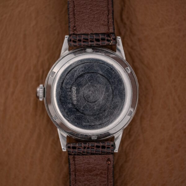 The back of a Gruen Precision Auto-Wind Copper Dial in Stainless Steel Cal. 400 wristwatch, featuring a worn case and brown leather strap.